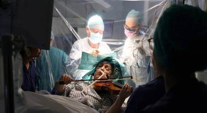 Mulher tocando violino durante cirurgia
