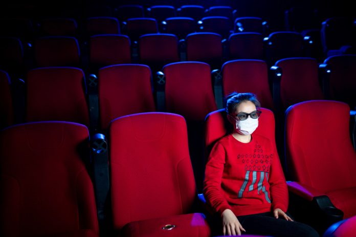 Pessoa usa máscara no cinema