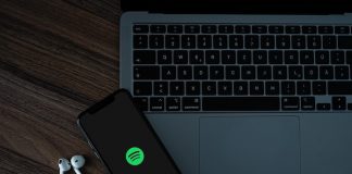 Celular com Spotify ao lado de Notebook