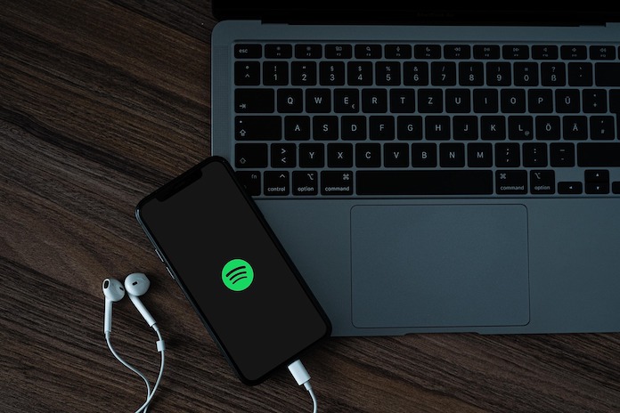 Celular com Spotify ao lado de Notebook