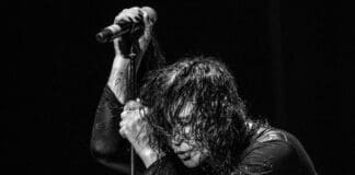 Ozzy Osbourne se apoiando em microfone
