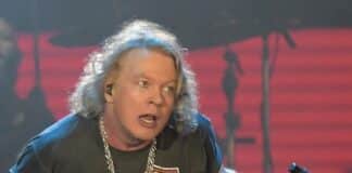 Axl Rose em show do Guns N Roses segurando pedestal do microfone