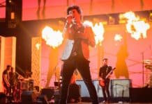 Billie Joe Armstrong cantando com o Green Day no palco em chamas
